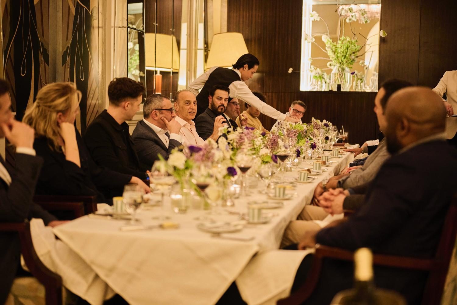 Guests seated along a long table at a Helm dinner