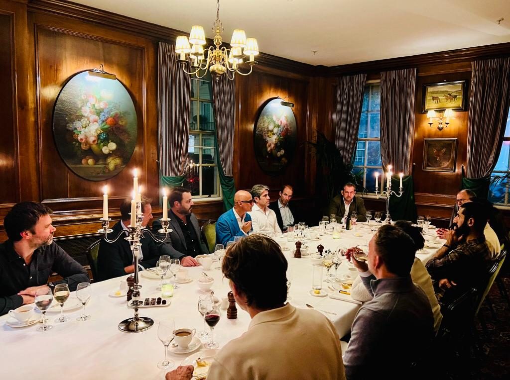 A small group of founders around one table in a private dining room